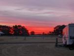 Sun setting with parked trailer and open RV spaces at Dreamin' 'n' Driftin' RV Resort - thumbnail