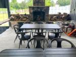 Table and chairs with a fireplace at FRANK'S AT CANE HOLLOW RV PARK - thumbnail