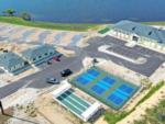 Aerial view of buildings construction, tennis courts and shuffleboard at WATERSIDE RV RESORT - thumbnail