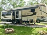 5th wheel parked on a gravel site surrounded by grass at Camper Village RV Park - thumbnail