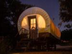 Covered wagon glamping at night at RIVER'S EDGE CAMPGROUND - thumbnail