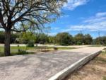 A gravel pull-thru site, picnic table and grill at RIVER'S EDGE CAMPGROUND - thumbnail