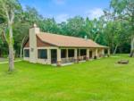 Exterior of the rec hall with lush lawn and trees at FARM OF DREAMS RESORT - thumbnail