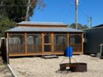 Enclosed pavilion with a fire ring in front at STEINHATCHEE VILLAGE RV PARK - thumbnail