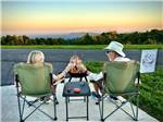 Couple in chairs at sunset at The Oaks RV Resort - thumbnail