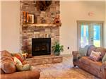 Seating area at a fireplace at The Oaks RV Resort - thumbnail