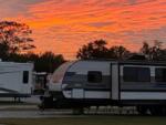 RVs against an orange sunset at PALM COVE RV VILLAGE - thumbnail