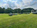 Vehicles parked on a grassy area at Still Waters Campground - thumbnail