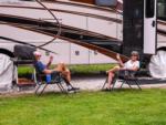 A couple lounging beside their rig at OUR FRIENDS CAMPGROUND - thumbnail