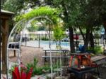 An ivy covered trellis in a garden setting at OUR FRIENDS CAMPGROUND - thumbnail