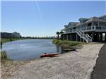 Kayaks at the shore of the pond at Galveston Island RV Park - thumbnail