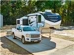 Truck and fifth wheel parked at a paved site at Blue Springs RV Park - thumbnail