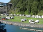 RV parks in grassy sites by water - thumbnail