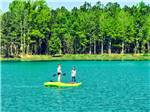 Children standing on a kayak on the lake - thumbnail