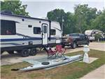 An RV parked at site with seating and kayak - thumbnail