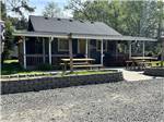 A brown building with picnic tables out front - thumbnail