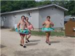 Teenage boys wearing ring floaties - thumbnail