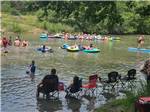 People floating and sitting in the river - thumbnail