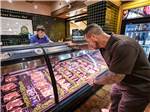 A man at the meat counter - thumbnail