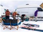 Parked RVs in winter with people and dog - thumbnail