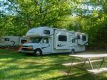 An RV parked in a shady site - thumbnail