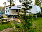 Trailer with a firepit at Plum Pines RV Park & Campground - thumbnail