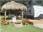 A thatched hut gazebo and fire pit at site - thumbnail