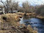 RVs parked alongside a stream - thumbnail