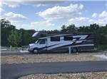 An RV parked in a paved site - thumbnail