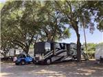 A motorhome beneath trees at MAXIE'S CAMPGROUND - thumbnail