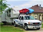 A truck with kayaks on top and trailer parked at WESTGATE RV CAMPGROUND - thumbnail
