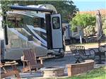Motorhome parked in gravel site with fire pit at BRYCE CANYON RV RESORT BY RJOURNEY - thumbnail