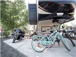 A pair of bikes under a fifth wheel at DESERT ROSE RV PARK - thumbnail