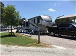 A fifth wheel and truck in a pull thru site at LAZY L RV PARK - thumbnail