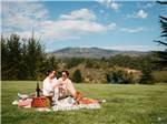 A couple and their dog enjoying a picnic - thumbnail