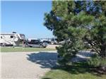 Gravel road and RV sites with RVs and trailers at A PRAIRIE BREEZE RV PARK - thumbnail