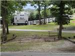 An empty RV site with benches at FORT WILDERNESS CAMPGROUND AND RV PARK - thumbnail