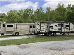 View larger image of A pair of RVs in a paved RV sites at BENCHMARK COACH AND RV PARK image #6