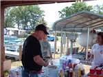 Man in black shirt with a plate of chili dogs at MOON LANDING RV PARK & MARINA - thumbnail