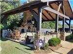 View larger image of Covered area with fireplace and seating at EAGLES LANDING RV PARK image #2