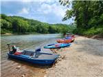 Kayaks and boats in a row at the river at BSC OUTDOORS CAMPING & FLOAT TRIPS - thumbnail