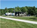 A row of trailers and motorhome parked in paved sites at BSC OUTDOORS CAMPING & FLOAT TRIPS - thumbnail