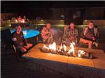 People sitting around a gas fire pit at KINGS RIVER RV RESORT - thumbnail
