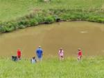 A family fishing in the pond at ASHLAND/HUNTINGTON WEST KOA HOLIDAY - thumbnail