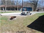 A picnic table and fire pit at RIFRAFTERS CAMPGROUND - thumbnail