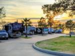 RVs parked on paved sites at sunset at On The Lake RV Resort - thumbnail