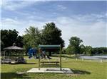 A swinging bench and playground equipment at SOMERSET BEACH CAMPGROUND & RETREAT CENTER - thumbnail