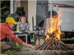 Man setting up a bonfire at BALLARD'S CAMPGROUND - thumbnail