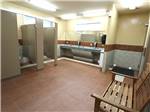 View larger image of Bathroom with bench stalls and sink at DESERT GEM RV RESORT image #8