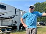 A man standing in front of a 5th wheel at Tranter's Creek Resort & Campground - thumbnail